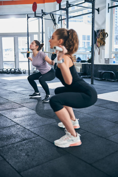 Mujeres atléticas haciendo ejercicio con palos de gimnasia - Foto, Imagen