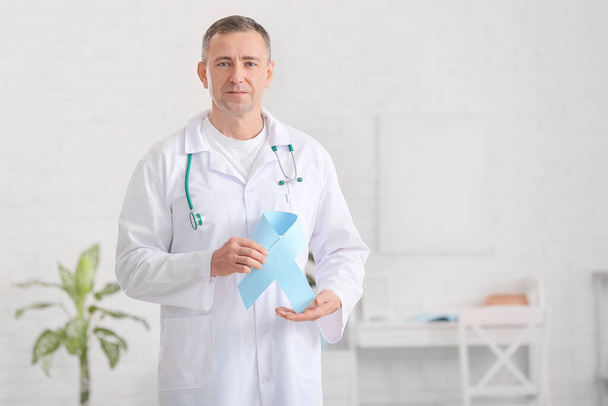 Онколог с голубой лентой в клинике. Концепция информирования о раке предстательной железы - Фото, изображение