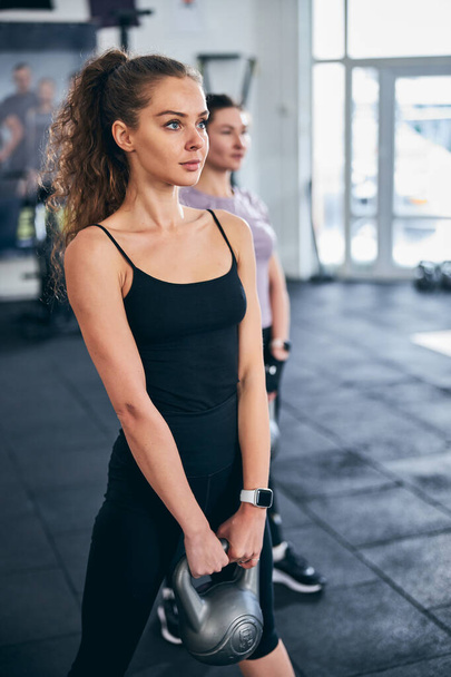 Zwei kaukasische Sportlerinnen trainieren mit Gewichten - Foto, Bild