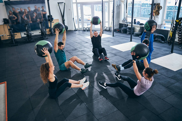 Two young women and three men working out together - Photo, Image