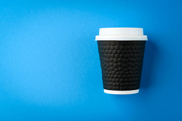 Papírový šálek kávy na modrém pozadí. Horní pohled. - Fotografie, Obrázek