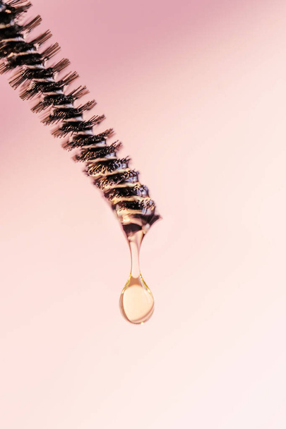 A drop of oil for eyebrows and eyelashes falls from the brush - Фото, изображение