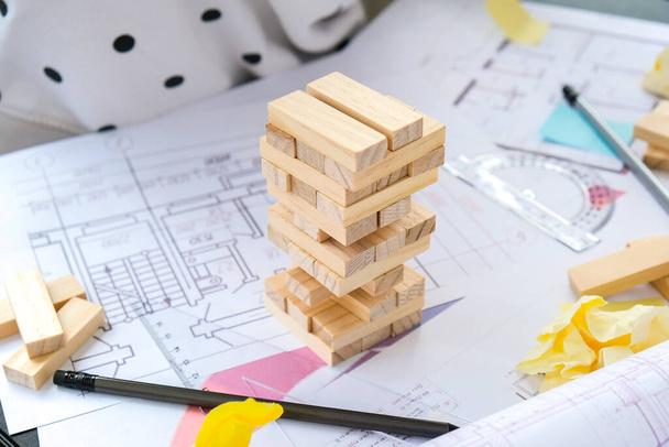 Építész tervező Belsőépítész kreatív dolgozó kéz játszik egy blokk fa játék íróasztal építészeti terv a ház, színes paletta. Női építész tervrajzokat rajzol az irodai munkahelyeken. Munkaterület - Fotó, kép