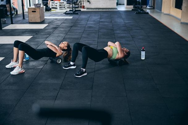 Professionele vrouwelijke atleten ontspannen hun bovenrug spieren - Foto, afbeelding