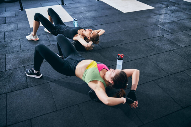 Αθλητικές γυναίκες που εκτελούν άσκηση κύλισης αφρού στο πάτωμα - Φωτογραφία, εικόνα