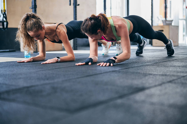 Две здоровые женщины работают над своими основными мышцами - Фото, изображение