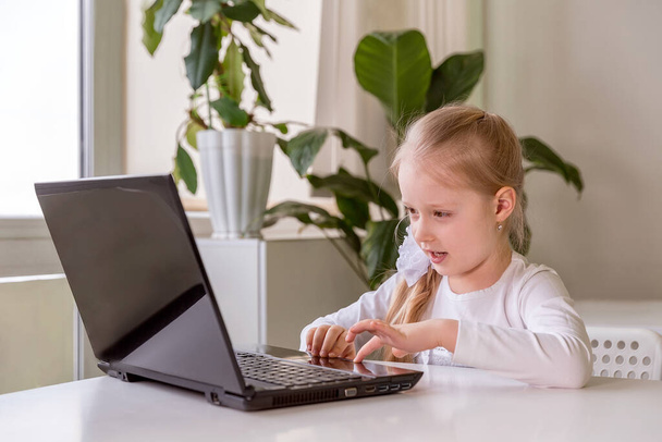 The girl learns (communicates, talks) through a computer / laptop - Φωτογραφία, εικόνα