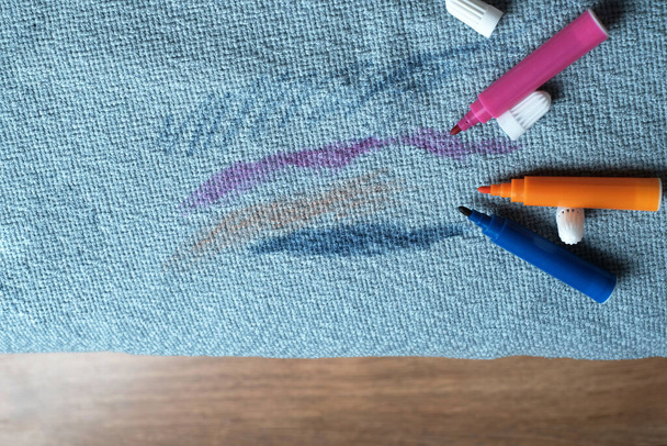Σχεδιασμένο μπλε ύφασμα στον καναπέ με χρωματιστά μολύβια. Στην κορυφή. Έννοια καθαρισμού - Φωτογραφία, εικόνα