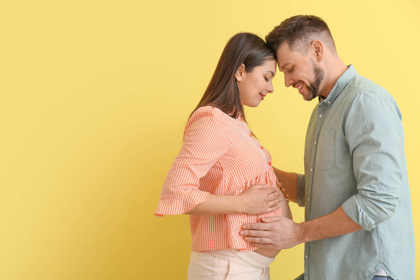Beautiful pregnant couple on color background - Photo, image