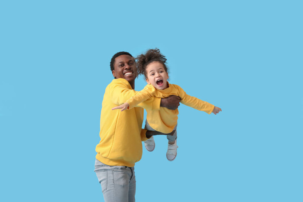 Portrét šťastného afroamerického otce a jeho dcery na barevném pozadí - Fotografie, Obrázek
