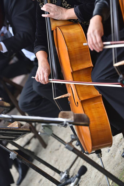 βιολοντσέλο κατά τη διάρκεια της συναυλίας, με τα χέρια του μουσικού και τόξο  - Φωτογραφία, εικόνα