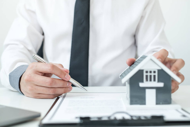 agenci zajmujący się inwestycjami w nieruchomości i ubezpieczeniami mieszkaniowymi podpisujący umowy zgodnie z umowami ubezpieczenia kupna domów zatwierdzającymi zakupy dla klientów. - Zdjęcie, obraz