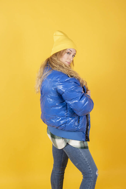 hezká žena s kloboukem a městské oblečení na žlutém pozadí - Fotografie, Obrázek