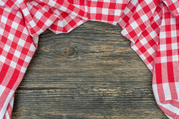 Toalha quadriculada vermelha na mesa da cozinha. Mesa de madeira fundo.  - Foto, Imagem