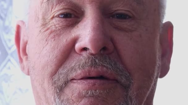 Älterer Mann blickt mit ernster Miene in die Kamera - Filmmaterial, Video