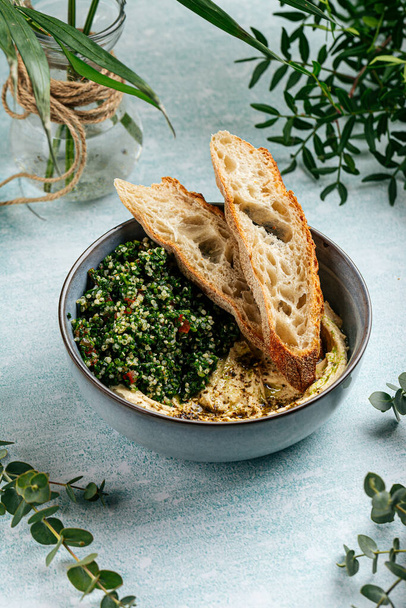 Schüssel Hummus mit Tabbouleh-Salat und Toasts - Foto, Bild
