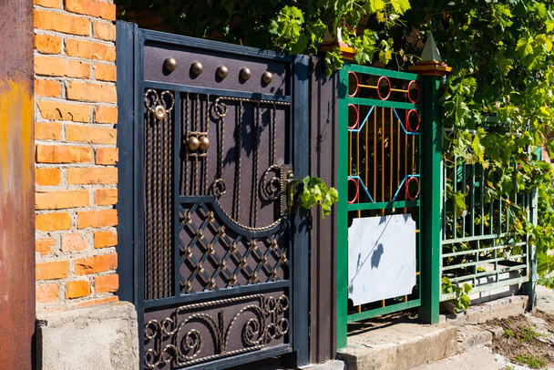 cancello in legno con elementi in ferro battuto vicino a un edificio residenziale. - Foto, immagini