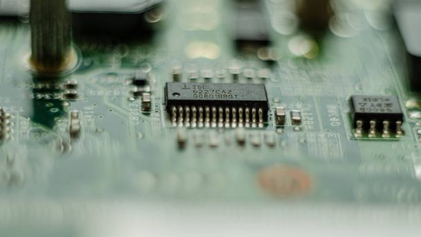 Complex electronics, green circuit board with a microcontroller, microprocessor control chip in the middle, extreme closeup detail macro, technology engineering abstract circuits industrial background - Photo, image