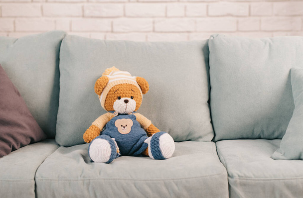 вязаный игрушечный медведь на диване - Фото, изображение