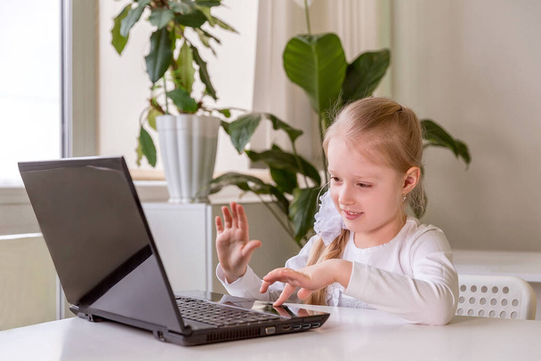 The girl learns (communicates, talks) through a computer / laptop - Фото, изображение