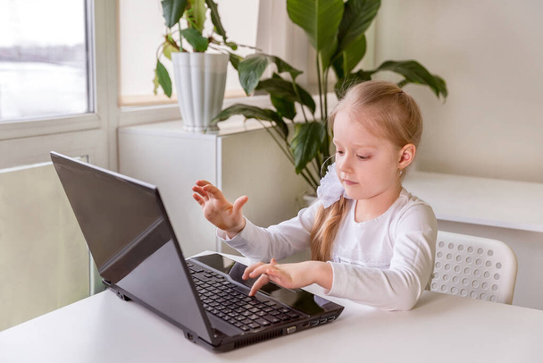 The girl learns (communicates, talks) through a computer / laptop - Foto, Bild