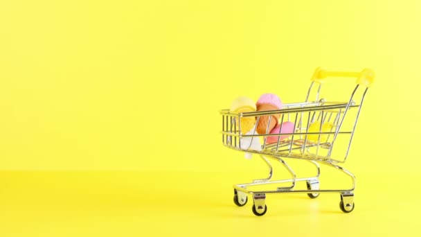 Winkelwagen met ijs binnen op een gele achtergrond, close-up. Black Friday Shopping en Korting Concept. - Video