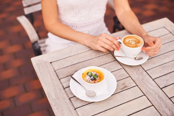 Kadın nefis kafein içer aromalı latte üstüne kremalı krema ve karamelize şeker. - Fotoğraf, Görsel