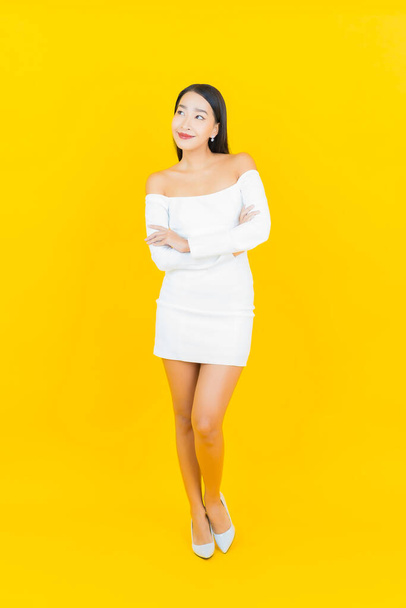 Porträt schöne junge Geschäft asiatische Frau mit Lächeln und Aktion gelben Hintergrund - Foto, Bild