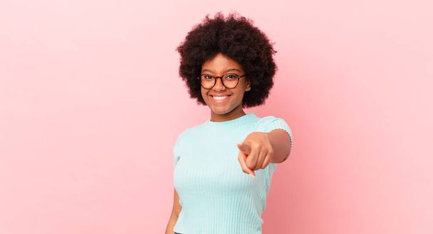 afro black woman pointing at camera with a satisfied, confident, friendly smile, choosing you - Фото, изображение