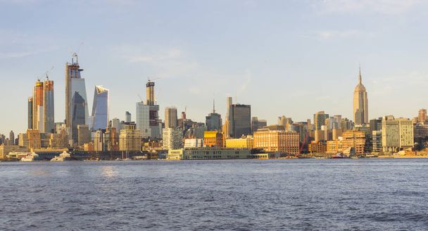 Linia górska Midtown Manhattan nad rzeką Hudson o zmierzchu w Nowym Jorku, Nowy Jork, USA. - Zdjęcie, obraz