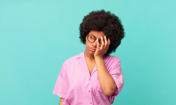afro black woman feeling bored, frustrated and sleepy after a tiresome, dull and tedious task, holding face with hand - Фото, изображение