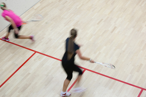 Dvě ženské squashové hráče v rychlou akci na squashovém kurtu (moti - Fotografie, Obrázek