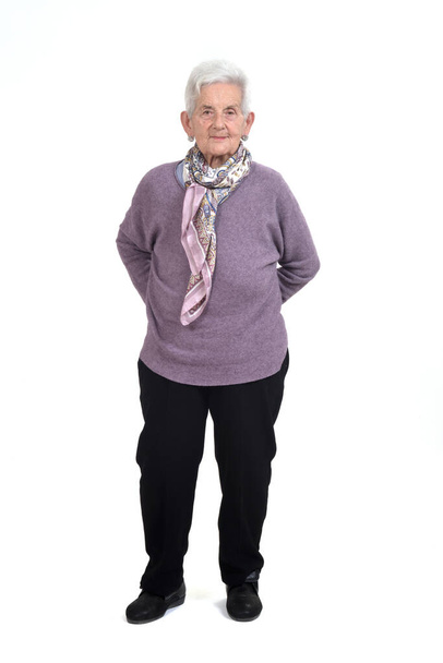 vista frontal de un retrato completo de una mujer mayor manos en la espalda sobre fondo blanco - Foto, Imagen