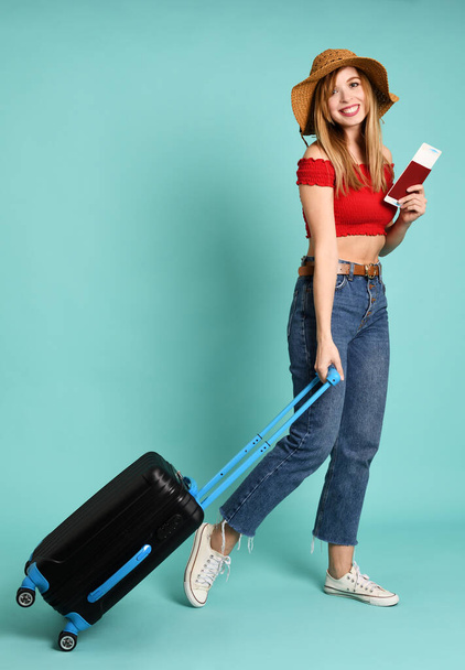 Young pretty woman with suitcase and passport on mint background - Photo, image