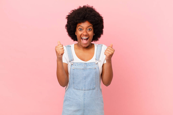 afro schwarze Frau fühlen sich schockiert, aufgeregt und glücklich, lachen und feiern Erfolg und sagen wow! - Foto, Bild