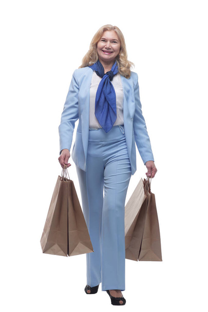 smiling mature woman with shopping bags striding forward. - Photo, image