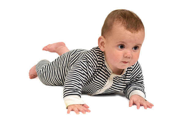  μωρό σέρνεται στο πάτωμα κοιτάζοντας έναν τρόπο σε λευκό φόντο - Φωτογραφία, εικόνα