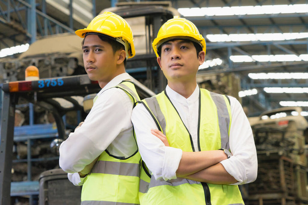 Ingeniero asiático trabajador hombres de pie y cruzados brazos en fábrica-almacén - Foto, imagen