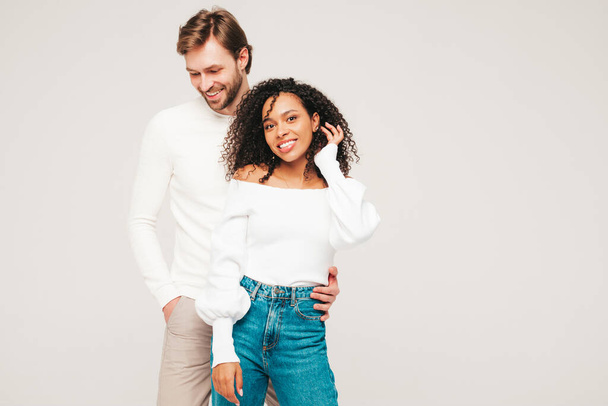 Smiling beautiful woman and her handsome boyfriend. Happy cheerful multiracial family having tender moments on grey background  in studio. Multiethnic models hugging. Embracing each other.Love concept - Photo, image