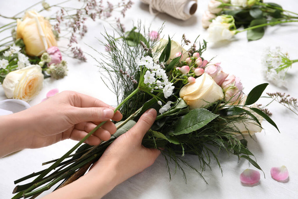 Florist making beautiful bouquet at white table, closeup - Zdjęcie, obraz