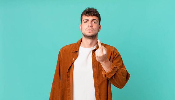 handsome man feeling angry, annoyed, rebellious and aggressive, flipping the middle finger, fighting back - Foto, afbeelding