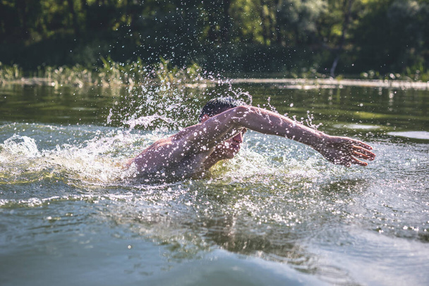 Mladý muž plavající v řece. - Fotografie, Obrázek