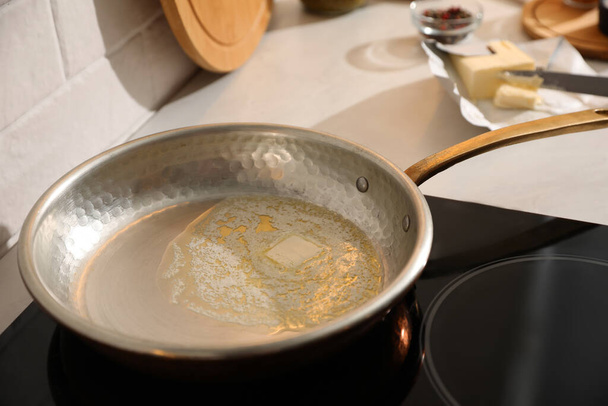 Frying pan with melted butter on stove, closeup - Fotografie, Obrázek