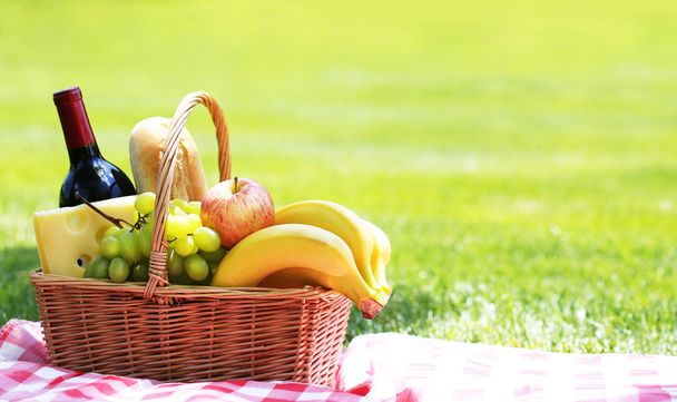 Picnic basket with food on green grass - Foto, Imagen