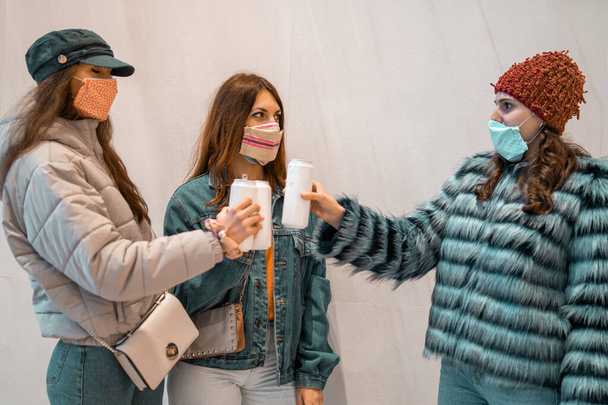 Молоді люди в масках для обличчя смердять консервованим пивом. Молодь возз'єдналася під час коронавірусу
. - Фото, зображення