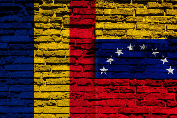 Σημαίες της Ρουμανίας και της Βενεζουέλας στον τοίχο από τούβλα - Φωτογραφία, εικόνα