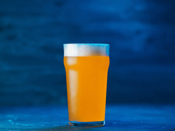 New England IPA craft beer glass on dark blue background - Zdjęcie, obraz