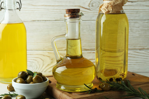 Bottles of olive oil against white wooden background - Фото, изображение