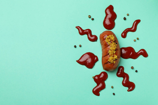 Grilled sausage with sauce and pepper on mint background - Photo, Image