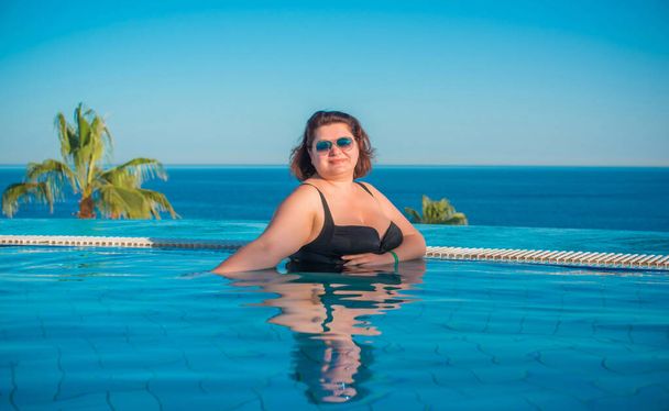  Συν μέγεθος γυναίκα μέσης ηλικίας στην πισίνα στην Αίγυπτο, διακοπές και να χαλαρώσετε έννοια, ταξίδια στην Αφρική - Φωτογραφία, εικόνα
